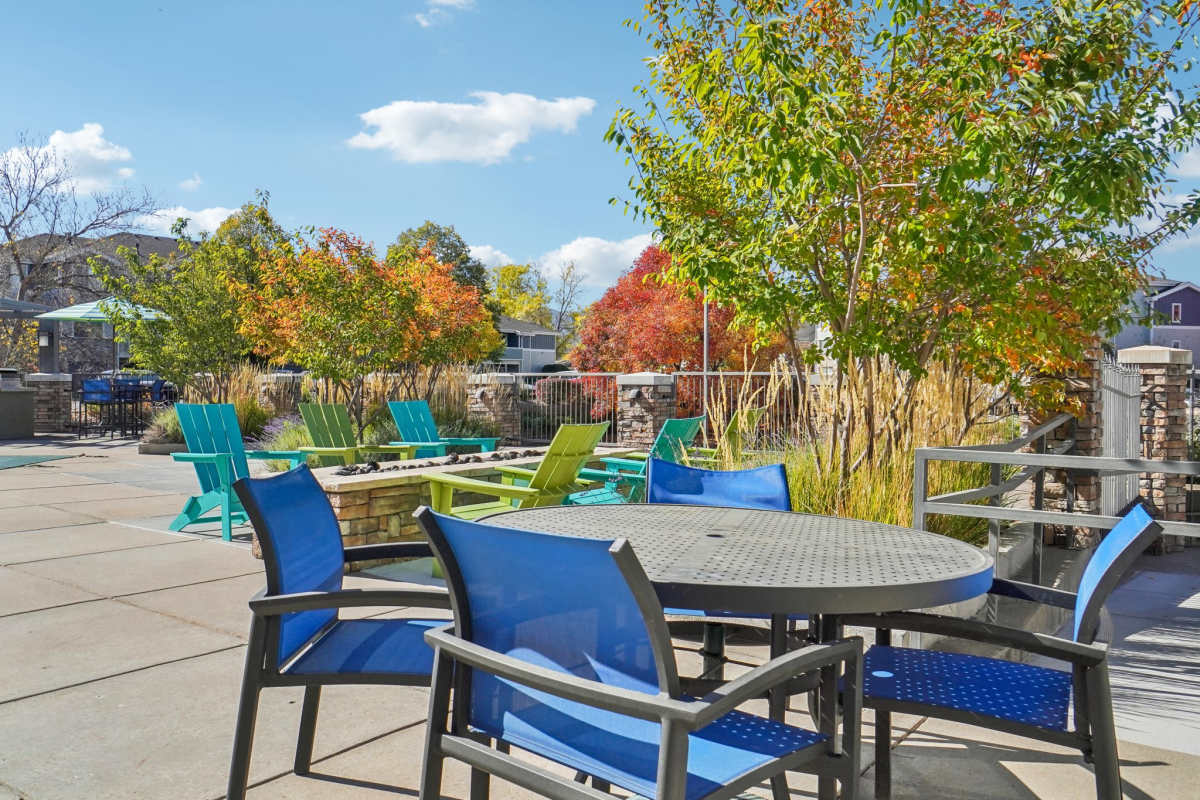 Paved outdoor patio with colorful seating, surrounded by autumn trees and landscaped greenery at Pavilions at Silver Sage in Fort Collins, Colorado.
