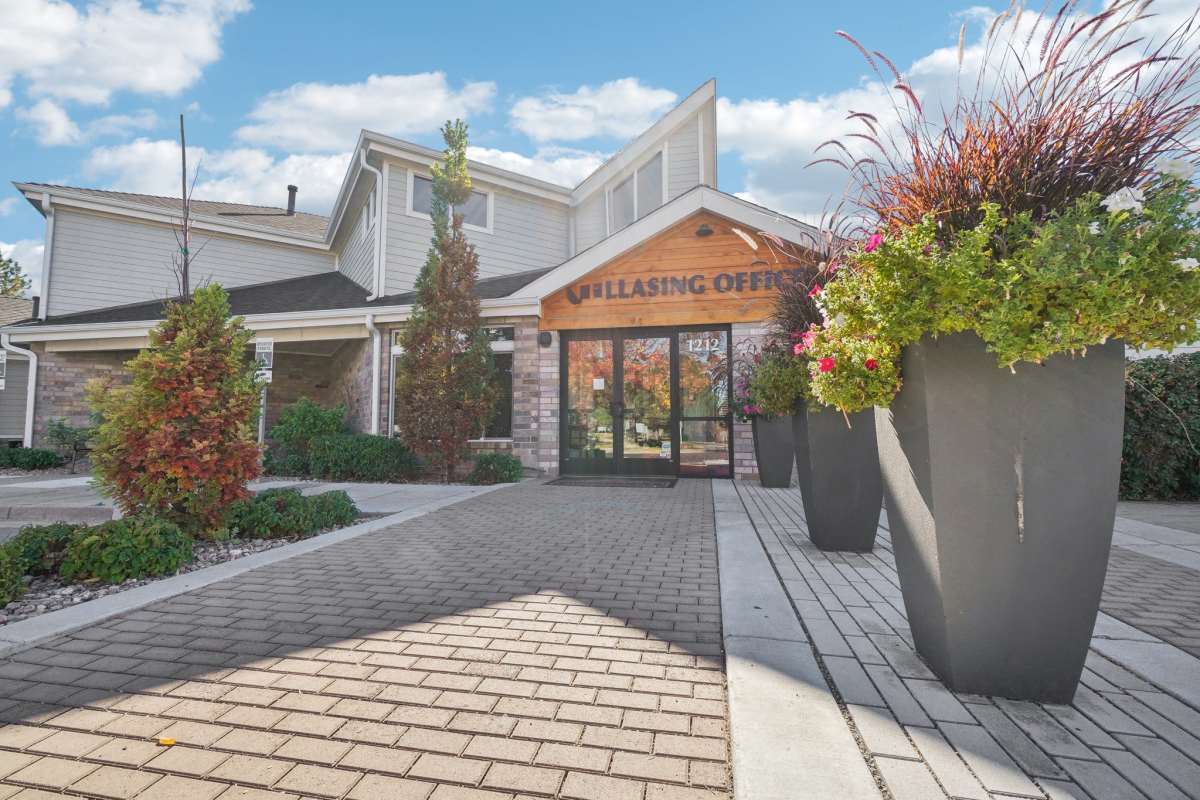 Paved outdoor patio with colorful seating, surrounded by autumn trees and landscaped greenery at Pavilions at Silver Sage in Fort Collins, Colorado