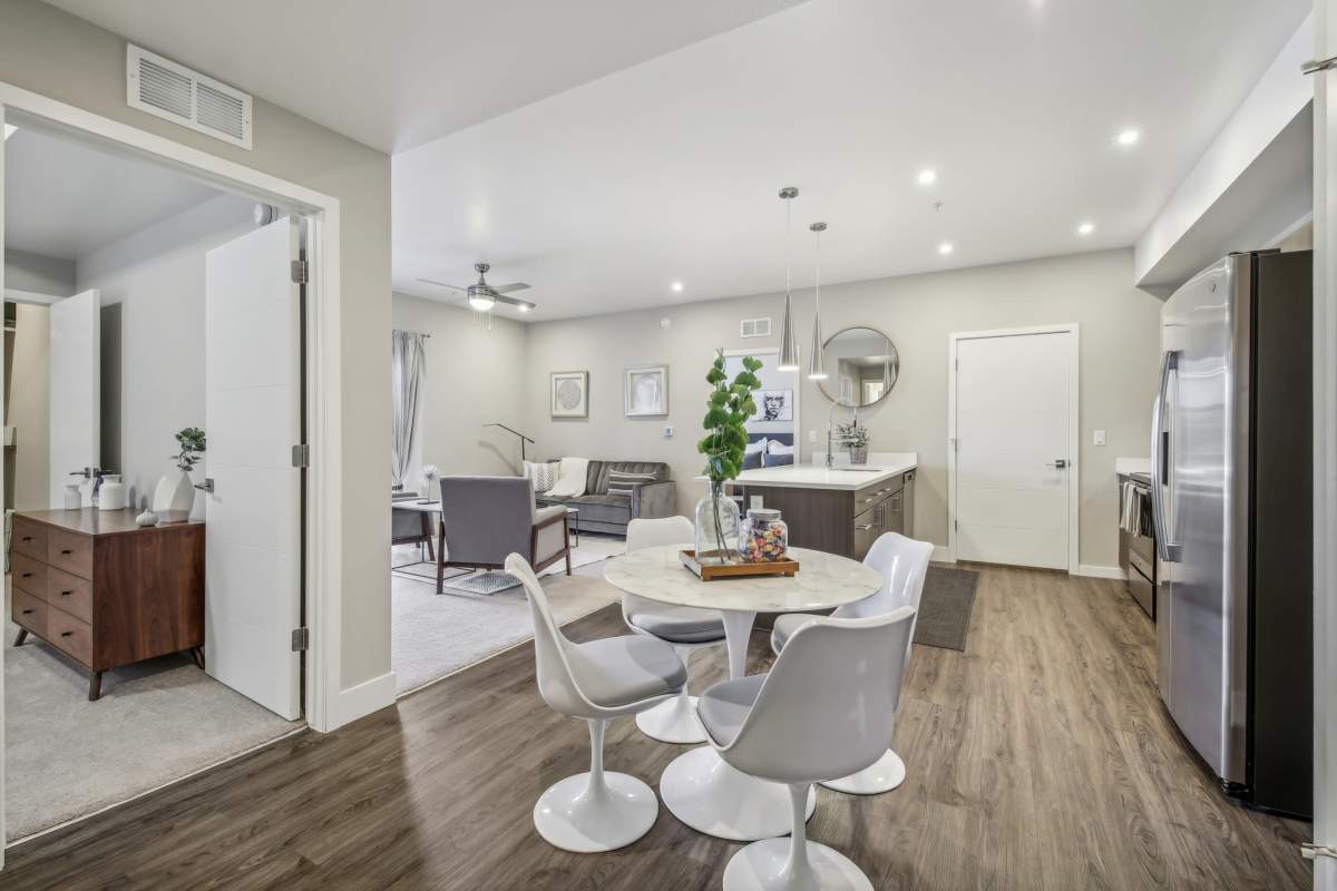 Bright and modern dining area with a round table, stylish chairs, and an open layout leading into a living space, at The Wyatt Apartments in Fort Collins, Colorado