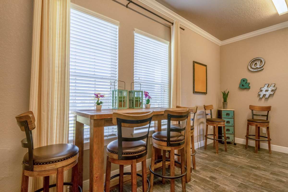 Dining nook with high-top table, bar stools, and decorative wall symbols at Century Lakehouse, Plant City, Florida