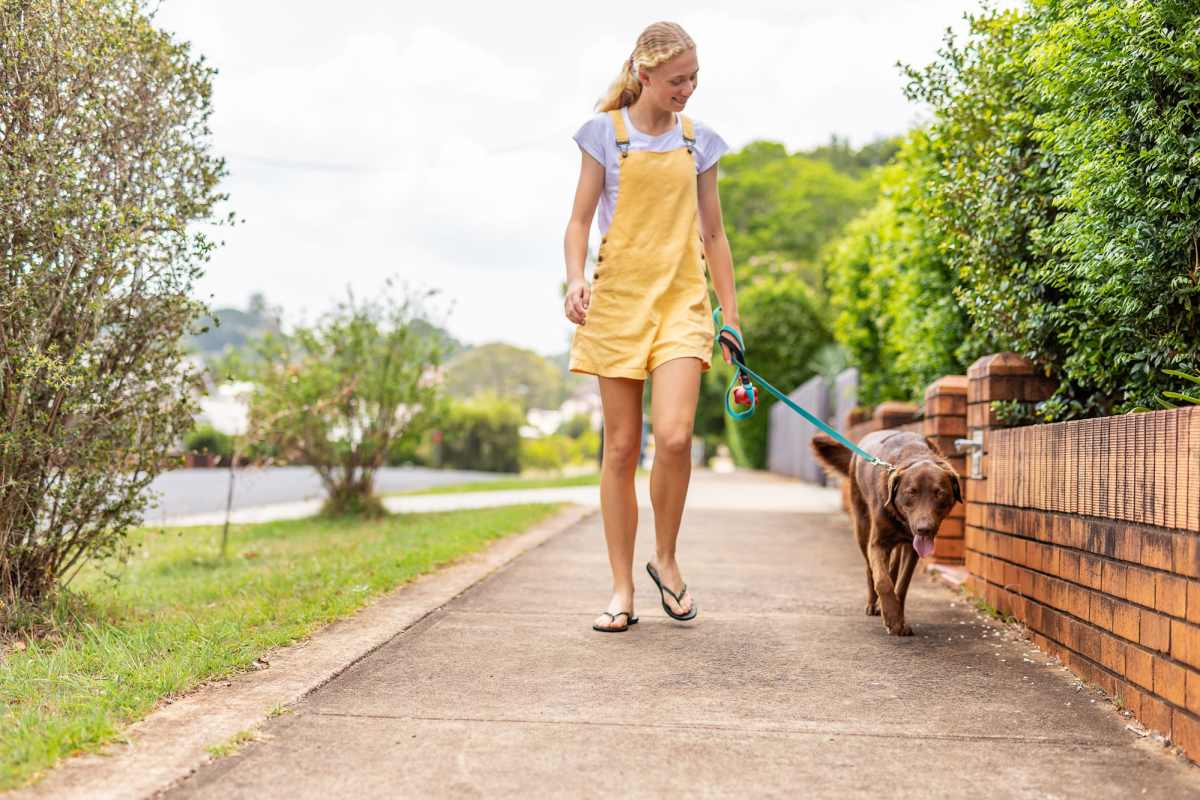 Resident walking with her pet dog at Copper Chase in Arlington, Texas