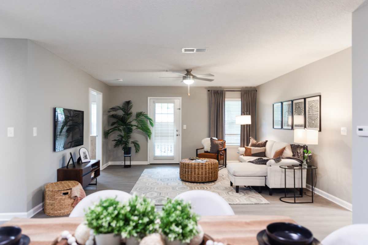 Model living space with ceiling fan at Atlas at Goodlett Farms in Cordova, Tennessee