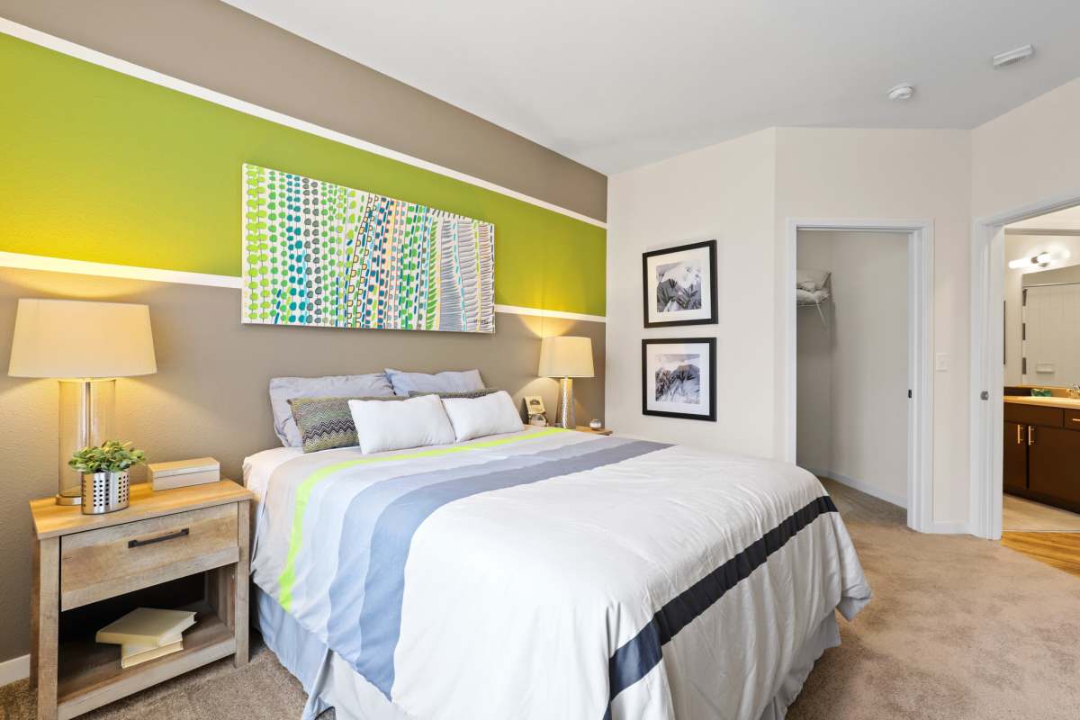 Bedroom with attached washroom at Westlink at Oak Station Apartments in Lakewood, Colorado 