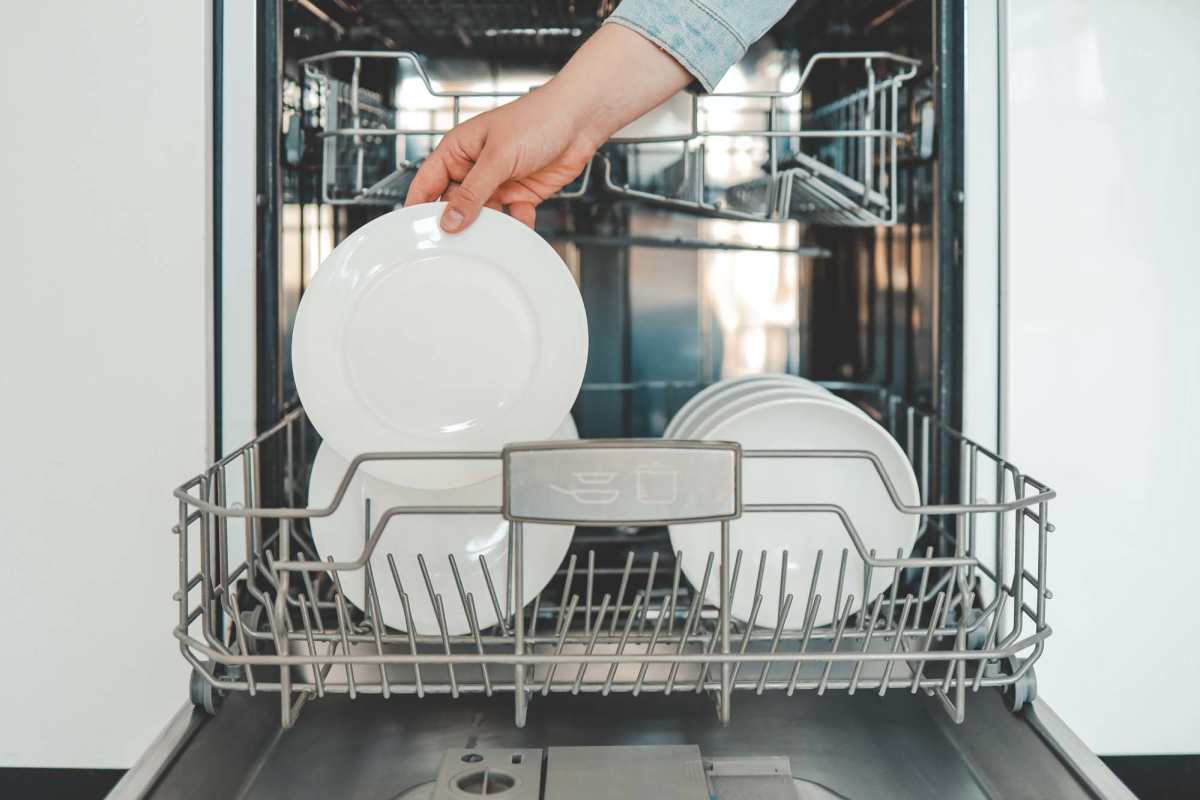 Woman put dish in a dishwasher at The Towns at Patuxent Overlook in Lexington Park, Maryland 