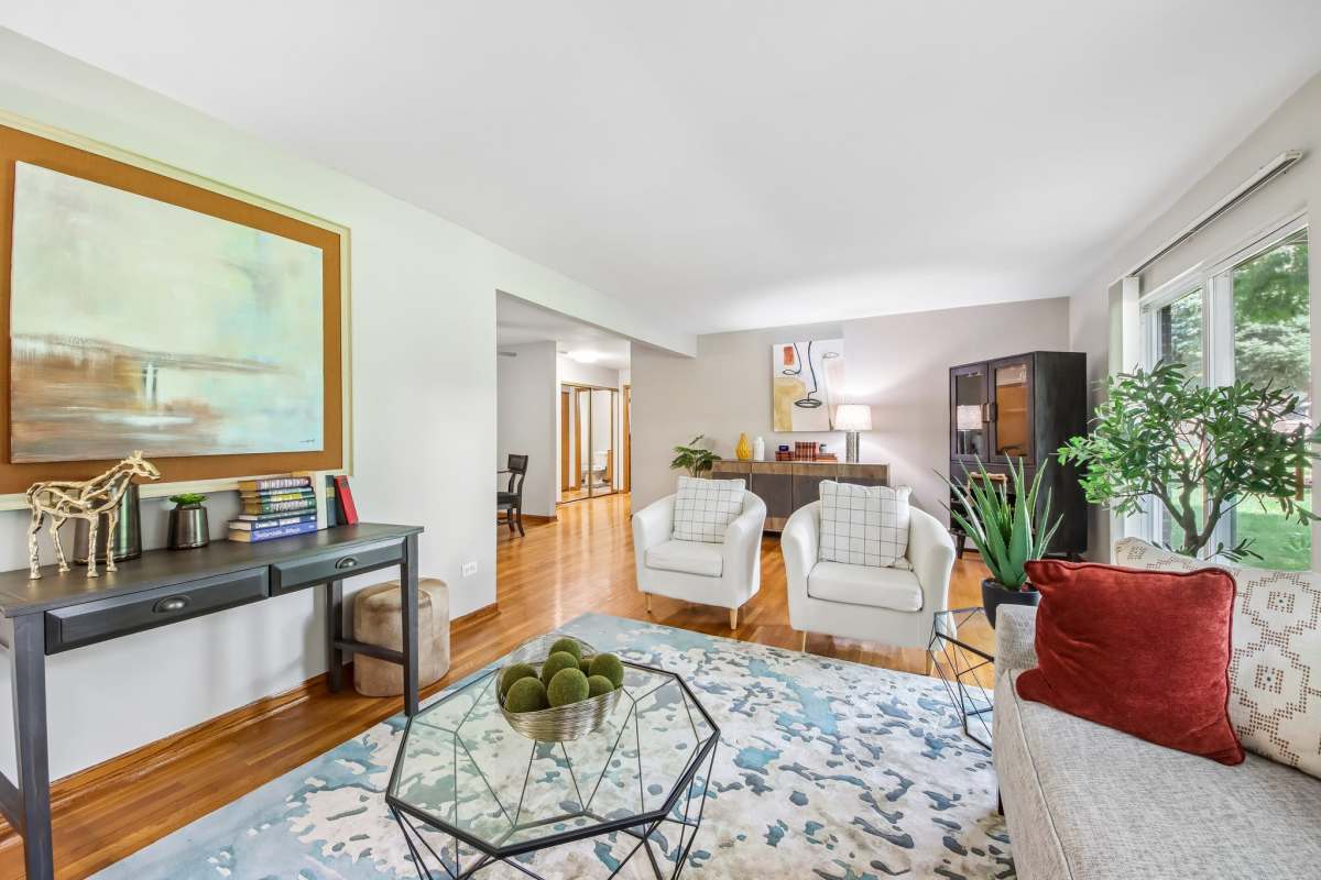 Well-lit bedroom with ceiling fan, large window, and hard-wood style flooring at  Park Ridge Commons in Des Plaines, Illinois