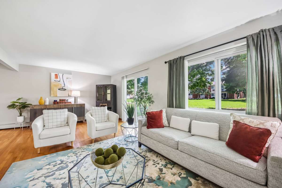 Bright and open living room with carpet and large window at  Park Ridge Commons in Des Plaines, Illinois