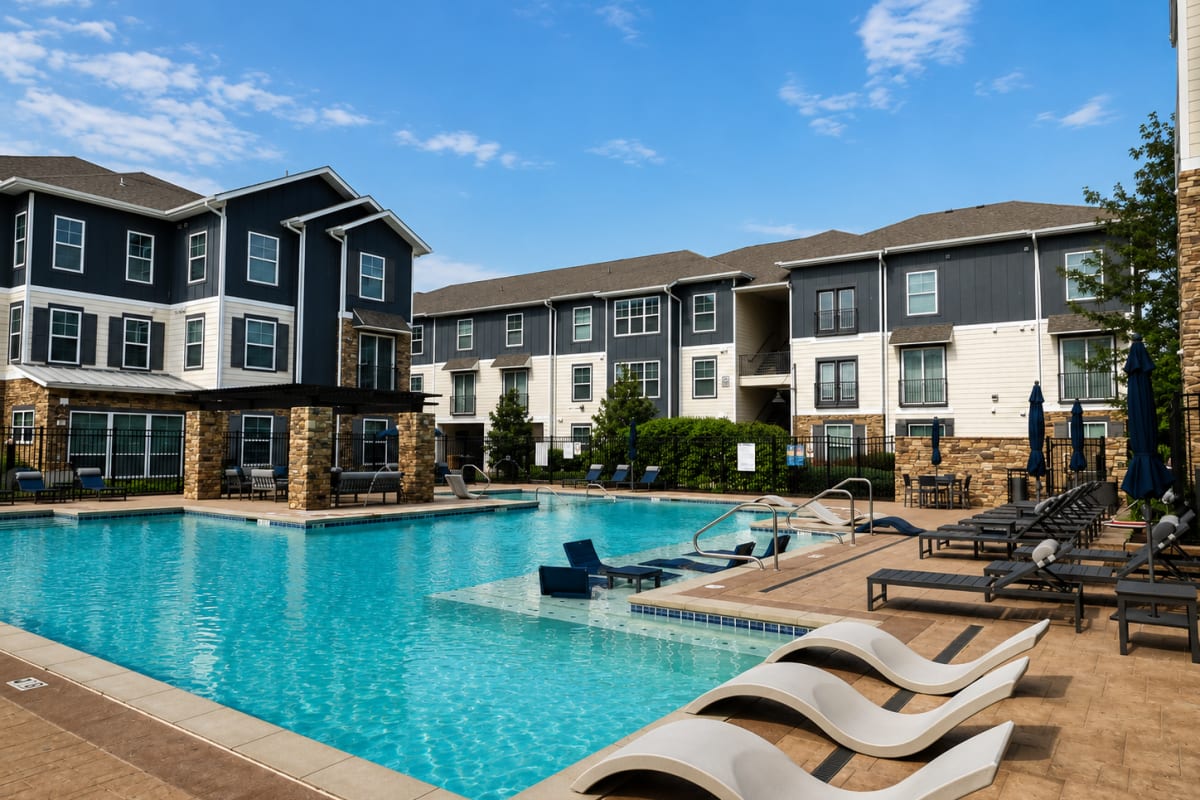 Swimming pool with sundeck and apartment buildings at The Den in Columbia, Missouri