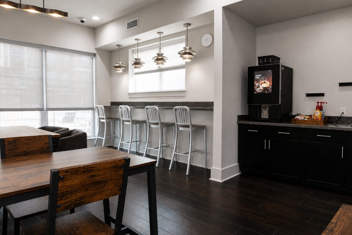 Clubhouse gathering area with kitchen bar seating at The Den in Columbia, Missouri