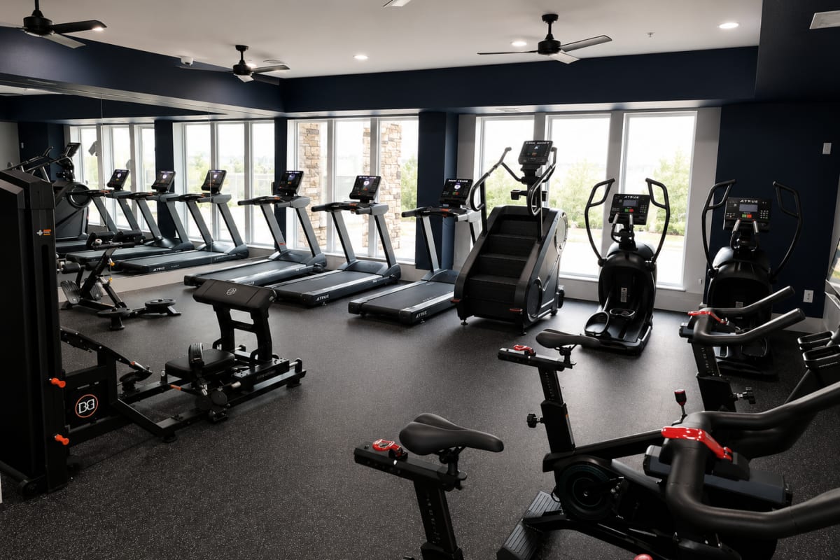 Fitness center with cardio machines and workout equipment at The Den in Columbia, Missouri