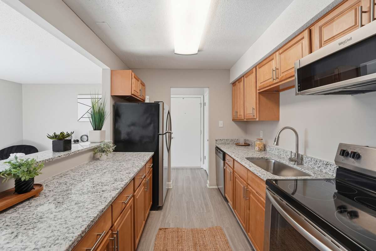 Granite countertop with wooden cabinets at Collins Crossing Apartments in Carrboro, North Carolina