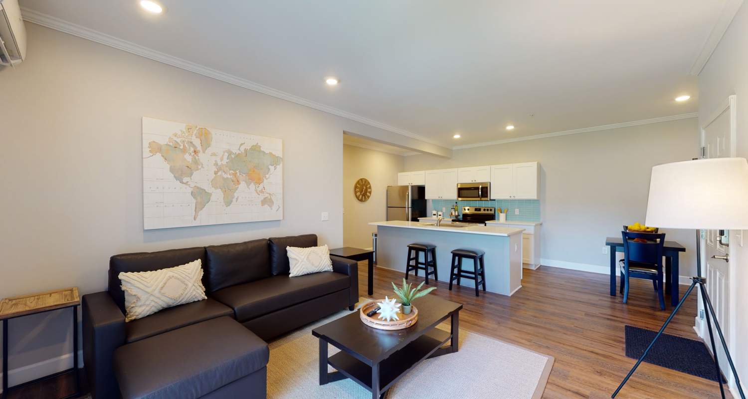 Spacious living room and kitchen in a model home at Coastal Club Apartments in Brunswick, Georgia