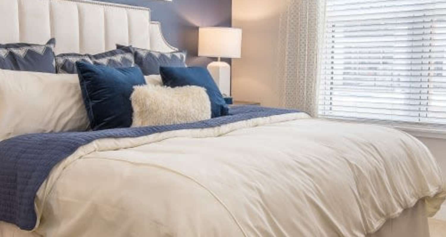 Comfortable bedroom with bedside lamp at Mayfair Reserve in Wauwatosa, Wisconsin