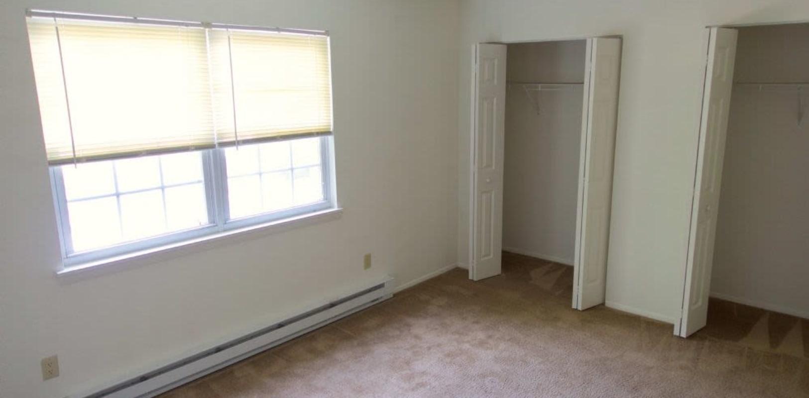 Bedroom with closet and large window with lots of light at Pine Crest Apartments in Milford, New Jersey