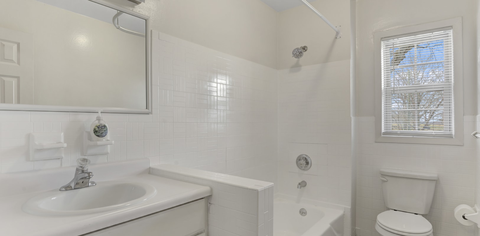 Bathroom with white tiles at Versailles Apartments in Ewing, New Jersey