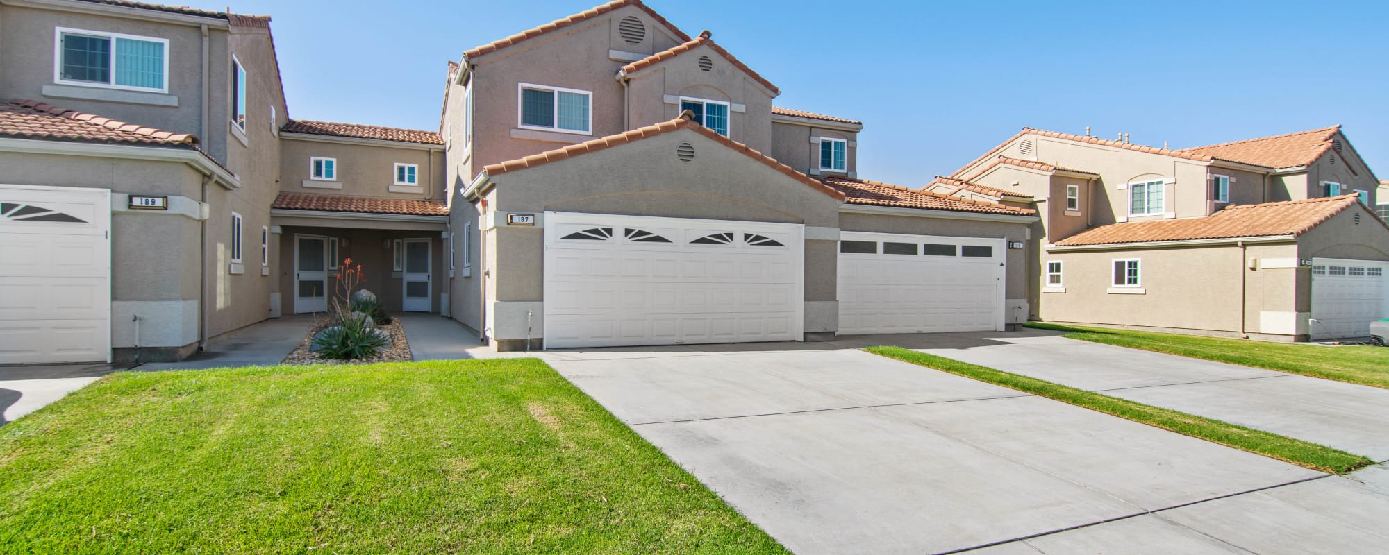Driveway and front yard of a duplex home at Pacific View in Oceanside, California