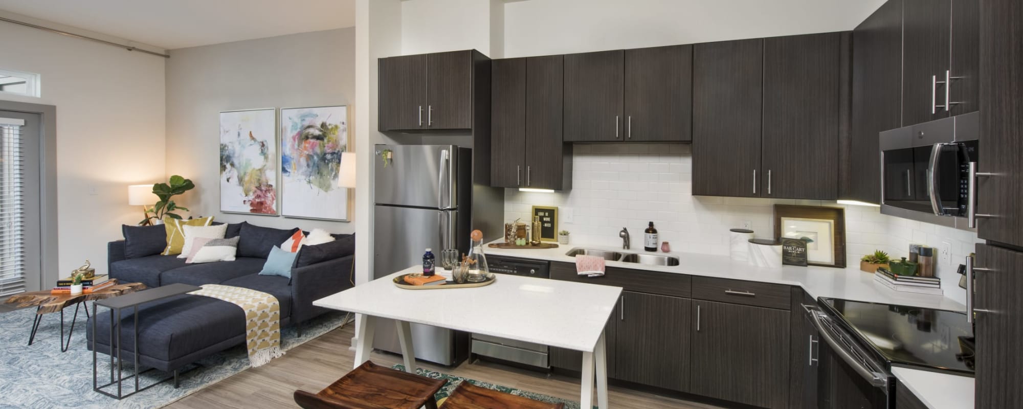 A furnished apartment living room and an open kitchen at Ravella at Town Center in Jacksonville, Florida