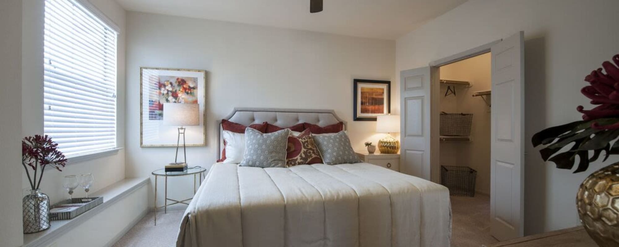 Master apartment bedroom with art on the walls and a walk in closet at The Crossing at Katy Ranch in Katy, Texas