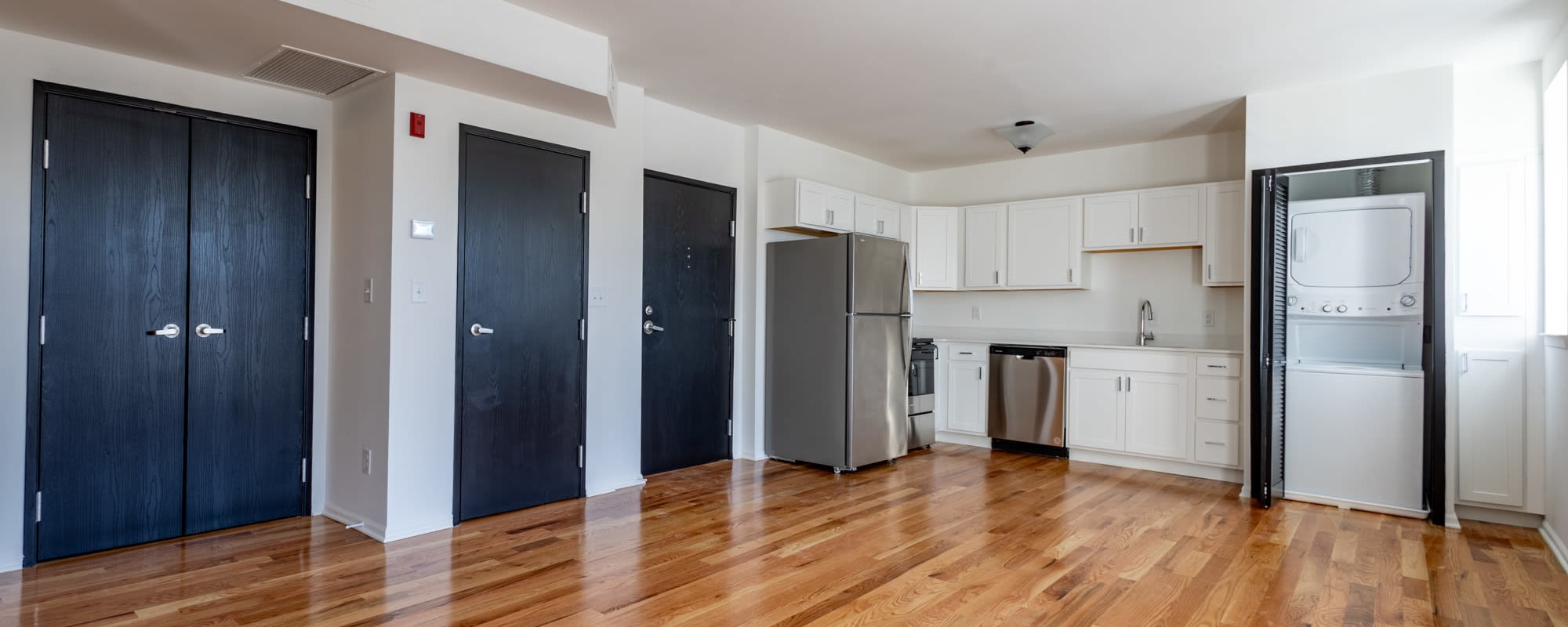 Living area with kitchen and hardwood flooring at Rink Savoy in Indianapolis, Indiana