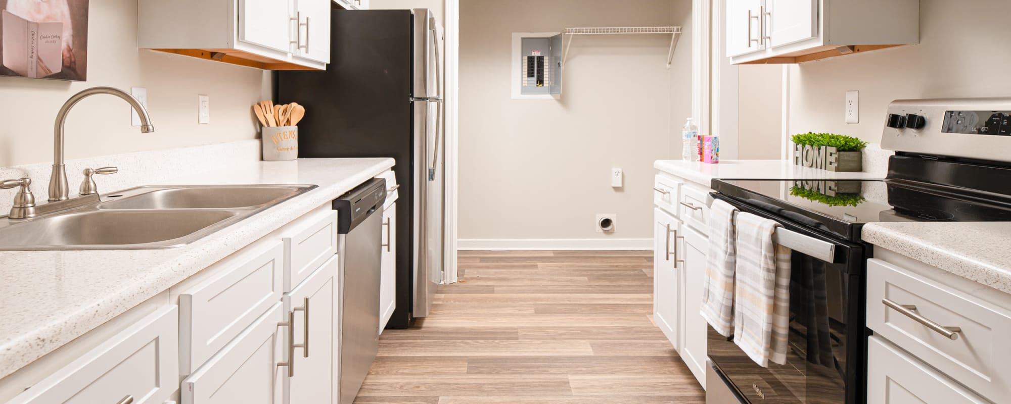 Spacious kitchen with wood flooring and white cabinetry at Bradford Place Apartments in Byram, Mississippi