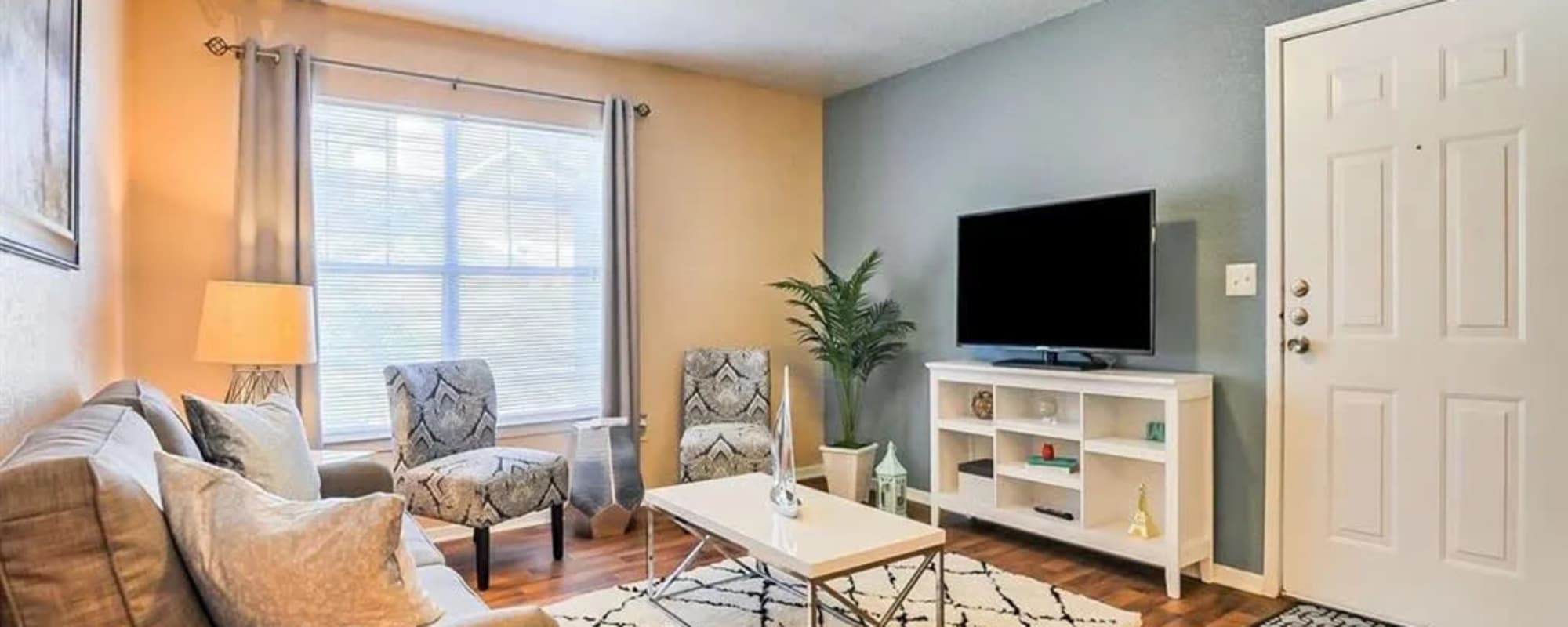 A furnished apartment living room with a painted accent wall at Reserve at Stillwater in Durham, North Carolina