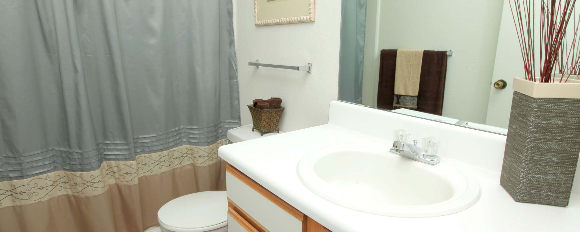Base cabinet with mirror and standard shower atNorth Oak Crossing in Kansas City, Missouri
