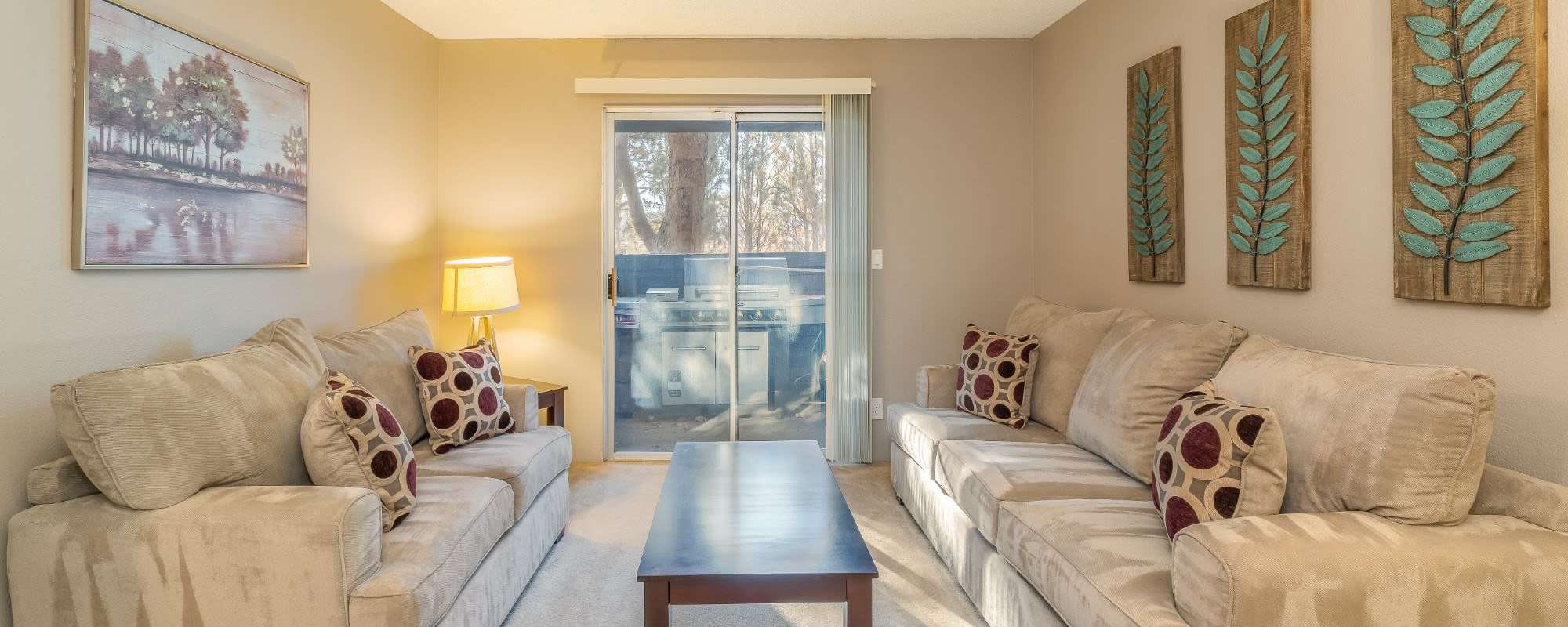 Model living room with sliding glass door at Rosewood Park Apartments in Reno, Nevada