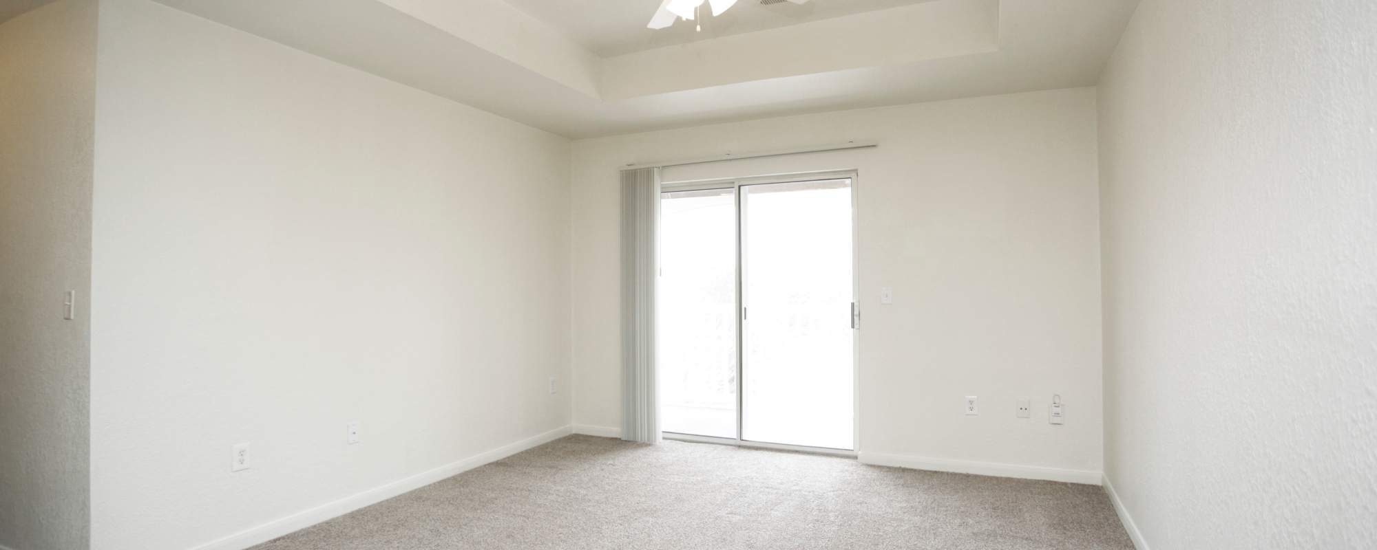Apartment living room with patio at North Oak Crossing in Kansas City, Missouri