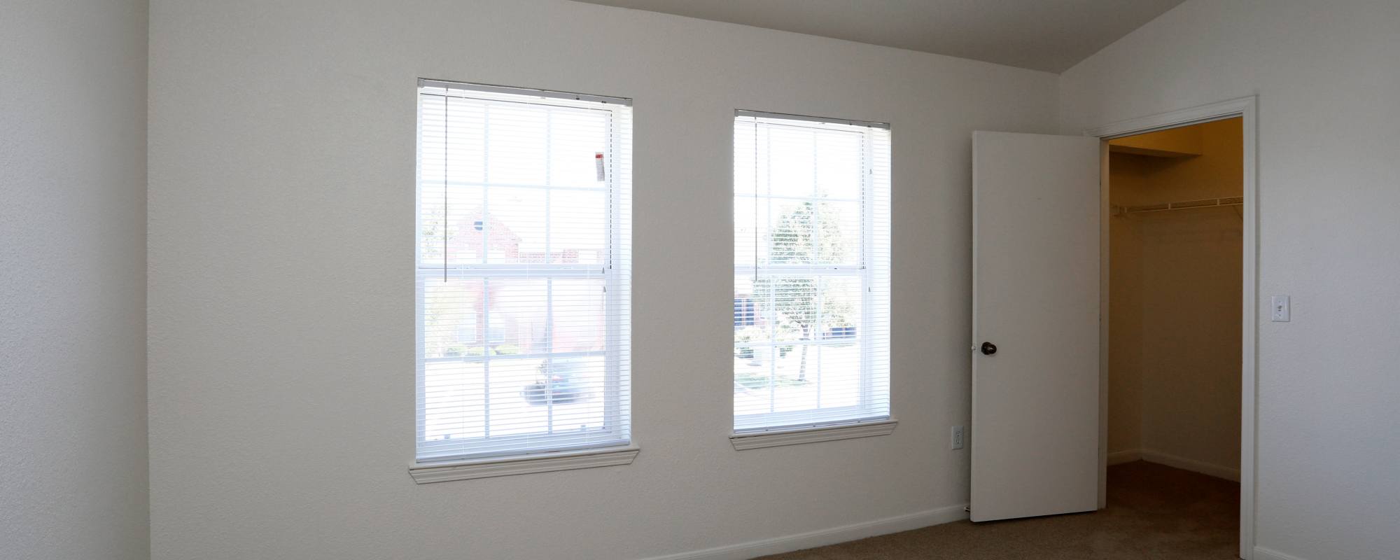 Empty bedroom with walk-in closet and window at Tyler's Creek Townhomes in Fairfield, Ohio