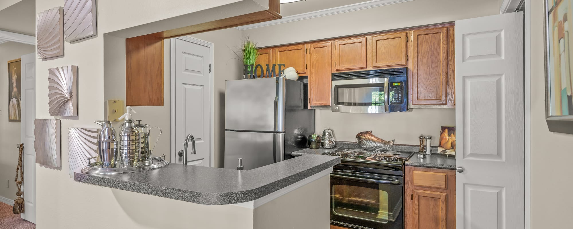 Modern kitchen with wooden cabinets and granite countertops at The Willows in Shreveport, Louisiana