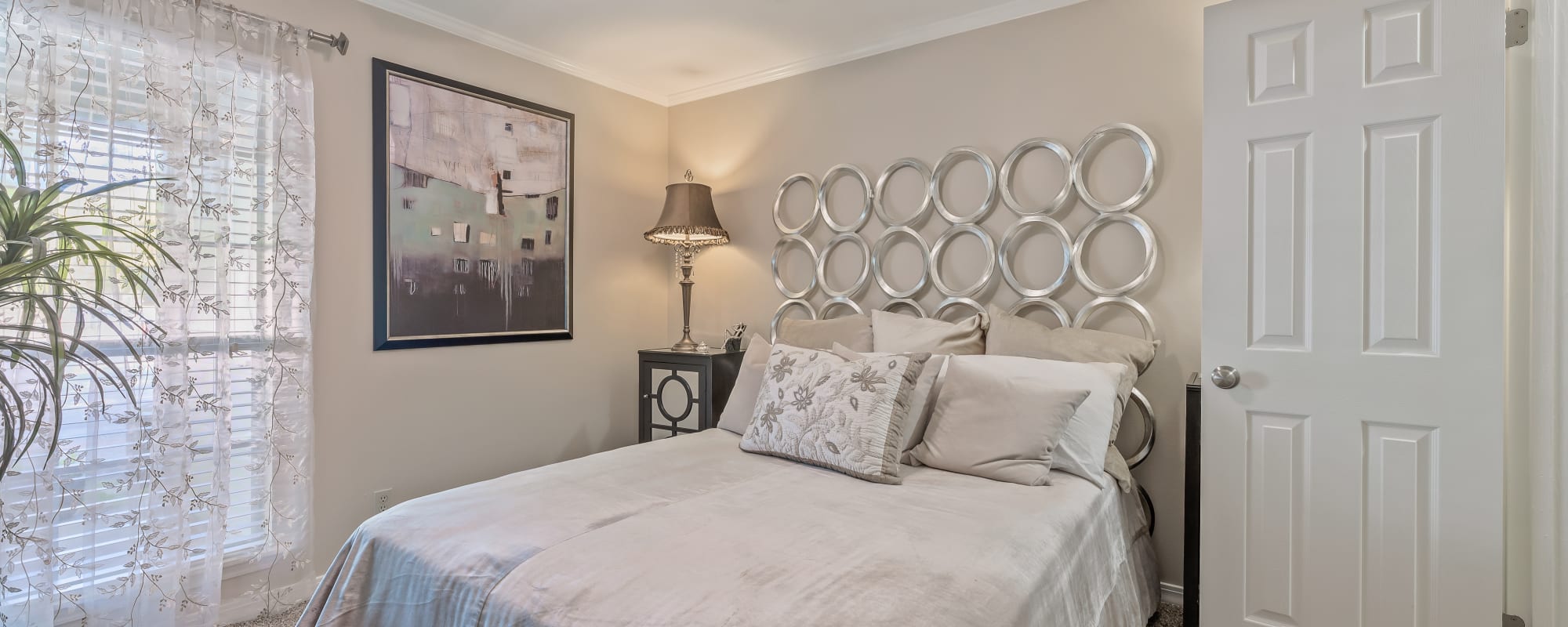 Well-lit bedroom with a bed, and a large window at The Willows in Shreveport, Louisiana