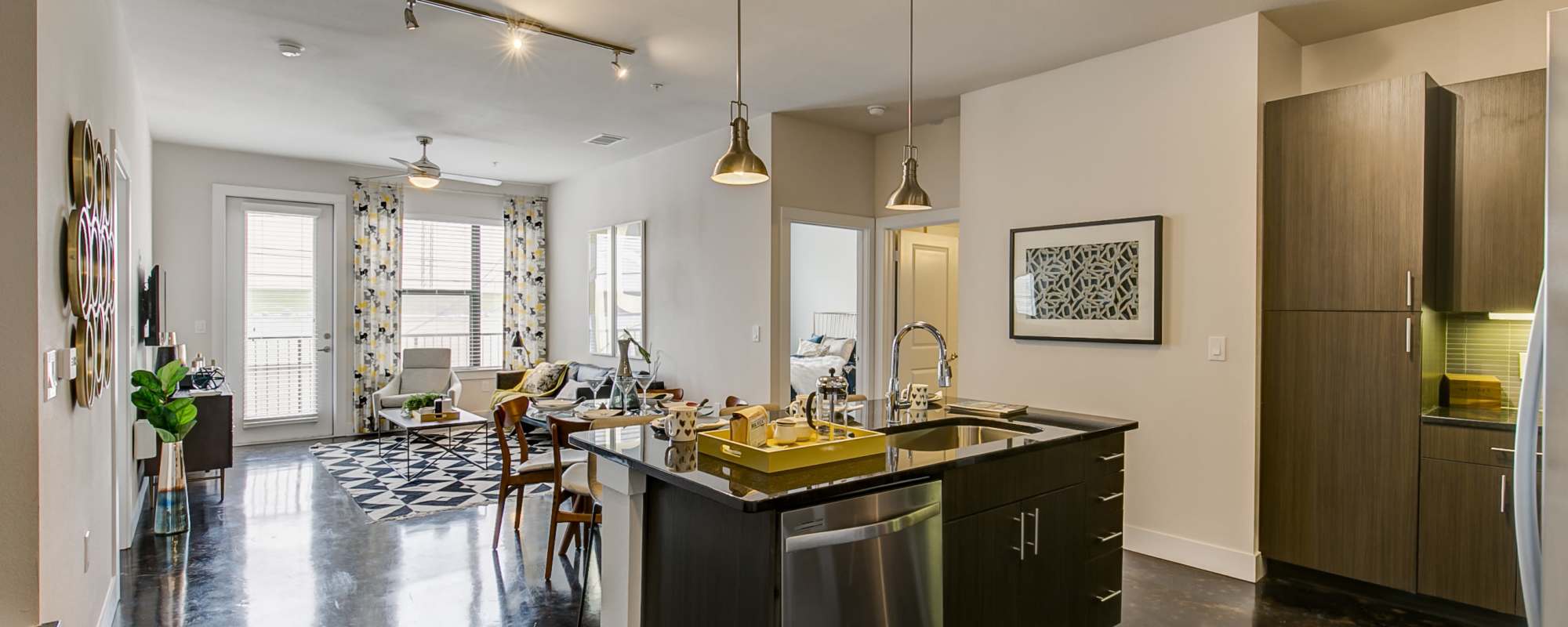 Island kitchen with black granite counter and dark cabinetry at Factory Design District in Dallas,Texas