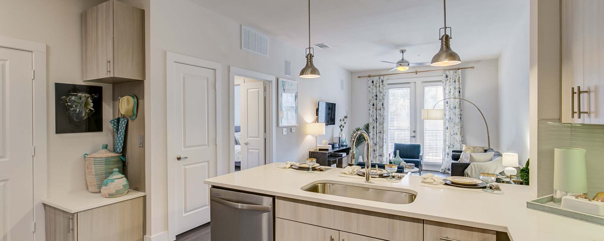 Apartment kitchen with stainless-steel dishwasher and patio in the background at Factory Design District in Dallas,Texas