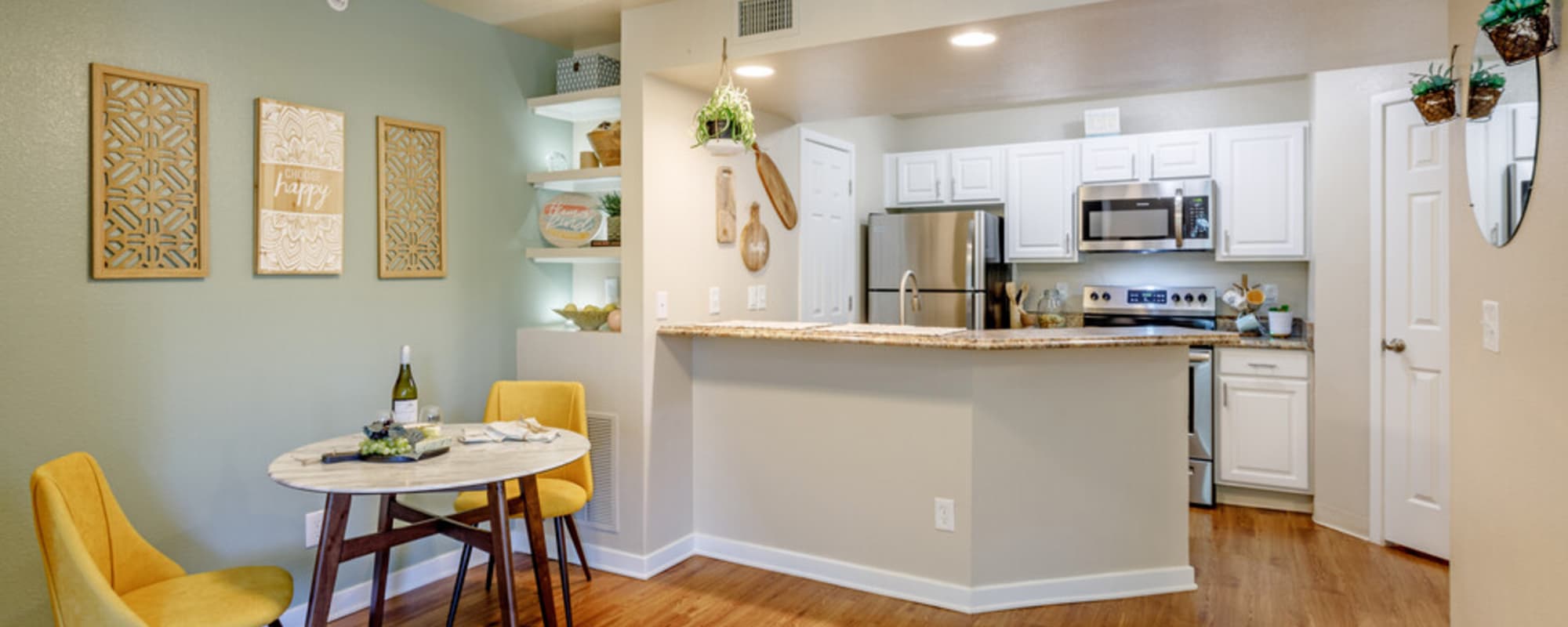 View of island kitchen and connected dining room at UTE Creek Apartments in Longmont, Colorado, 