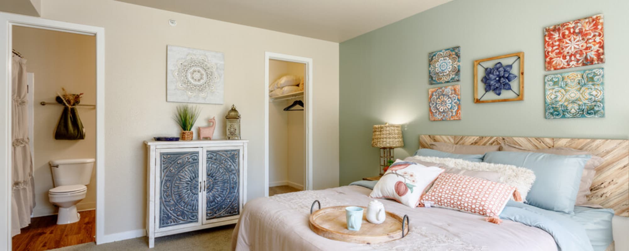 Well-lit bedroom with large comfortable bed at UTE Creek Apartments in Longmont, Colorado, 