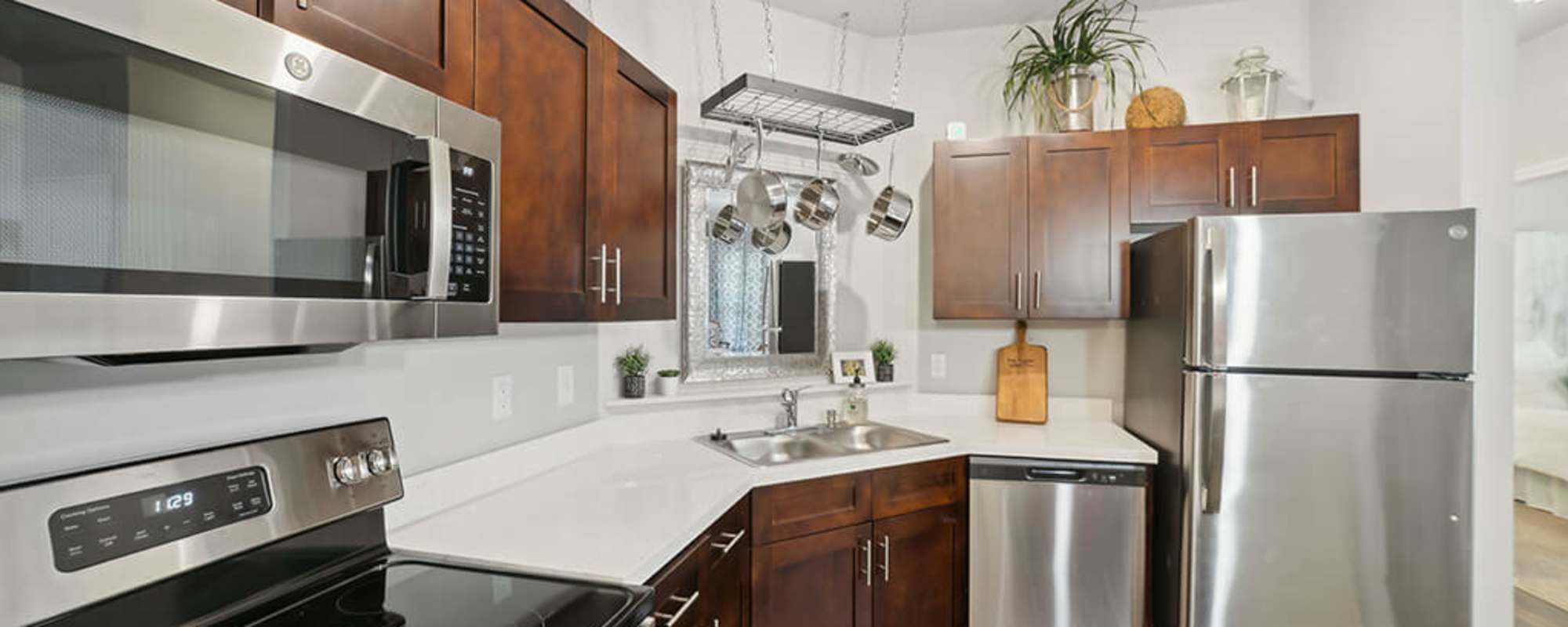 Kitchen with wood cabinetry in a model home at The Apartments at Shade Tree in Johns Island, South Carolina
