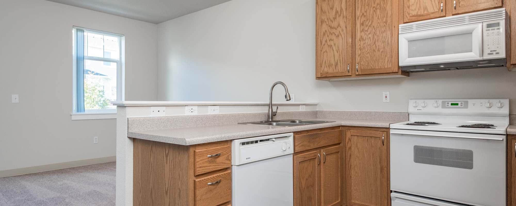 Kitchen with view to living room at Chinook Way Apartments in Fairview, Oregon