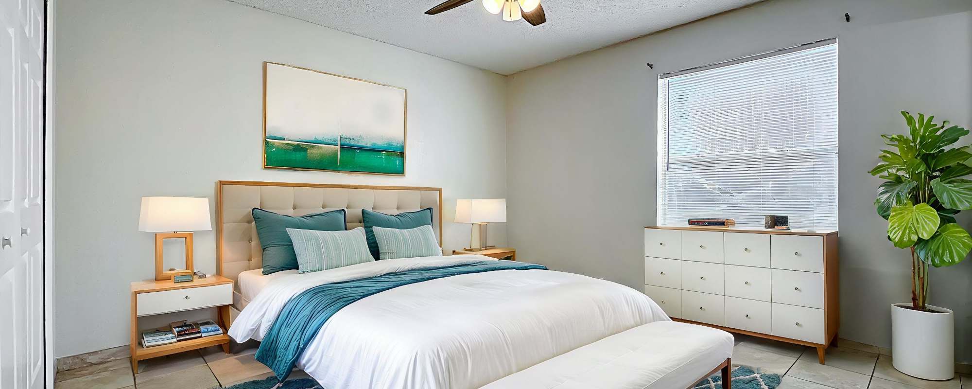 Modern bedroom with a large bed of Images Condominiums in Kissimmee, Florida