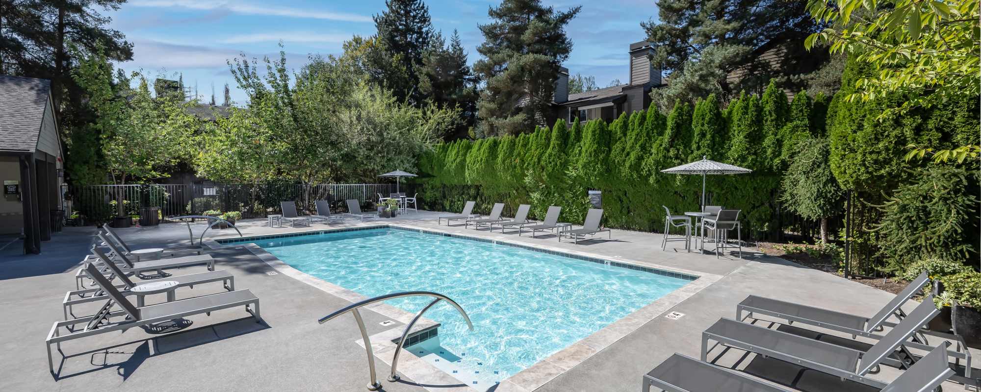 Swimming pool with lounge chair at Campbell Run Apartments in Woodinville, Washington