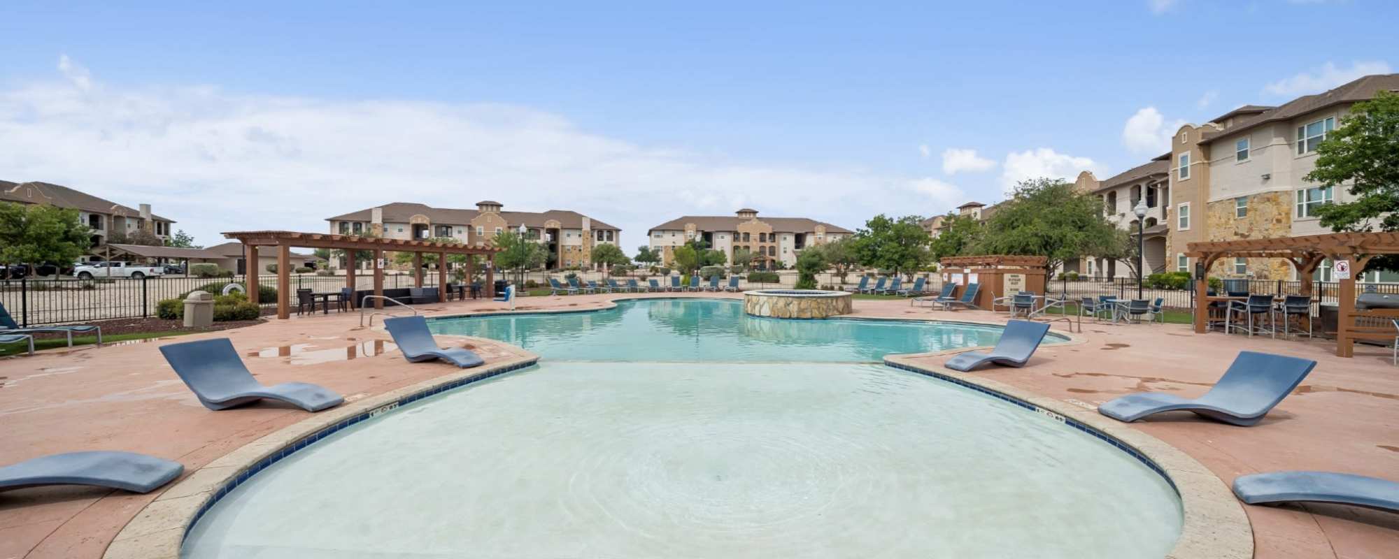 Outdoor swimming pool and lounges at Sunset Lodge in Odessa, Texas