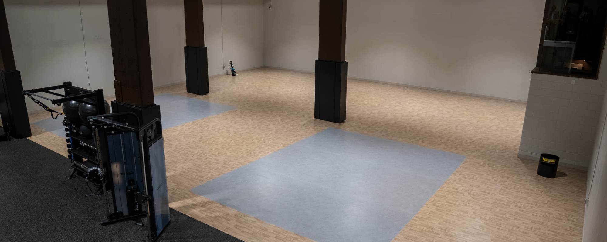 Spacious indoor fitness studio with wood flooring, workout mats, and exercise equipment at Residences at 111 Lyon in Grand Rapids, Michigan