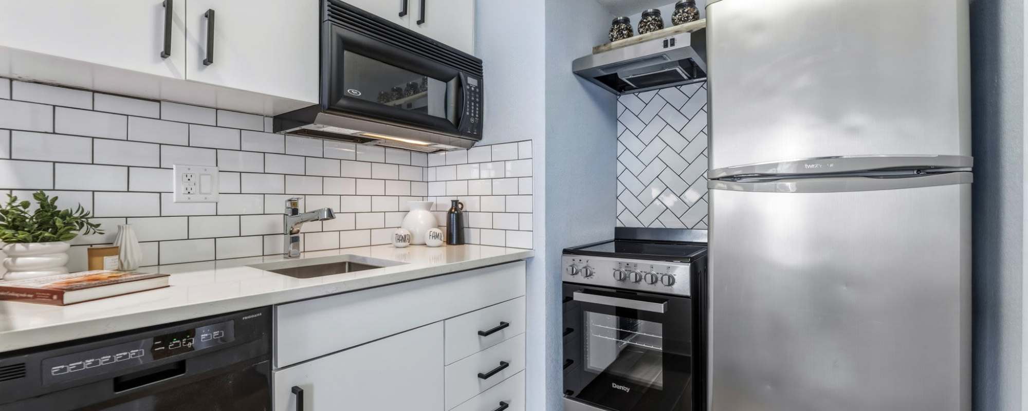 Kitchen with refrigerator at The Nora in Dallas, Texas