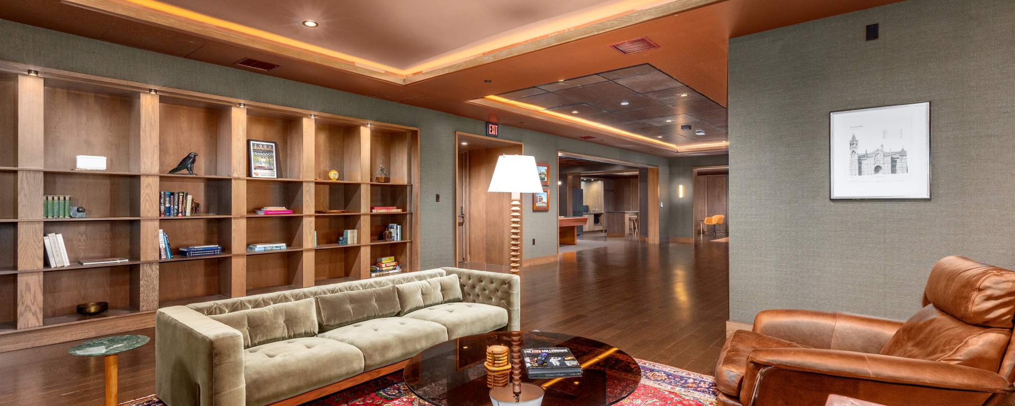Stylish community lounge with seating area, bookshelves, and wood finishes at Residences at 111 Lyon in Grand Rapids, Michigan