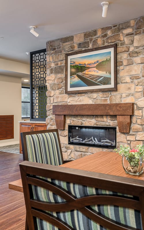 Resident dining area with electric fireplace at The Pillars of Grand Rapids in Grand Rapids, Minnesota