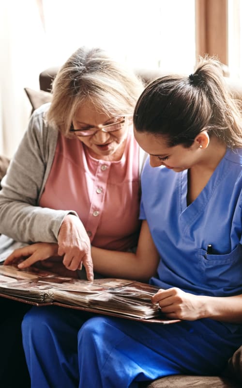 Resident reading with a nurse at Regency Care of Rogue Valley in Grants Pass, Oregon