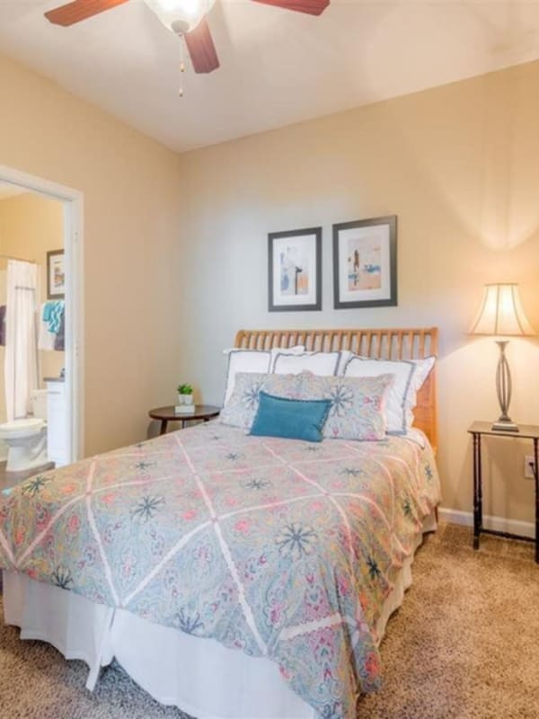 cozy and clean bedroom with large bed and ceiling fan at Braxton at Woods Lake in Greenville, South Carolina