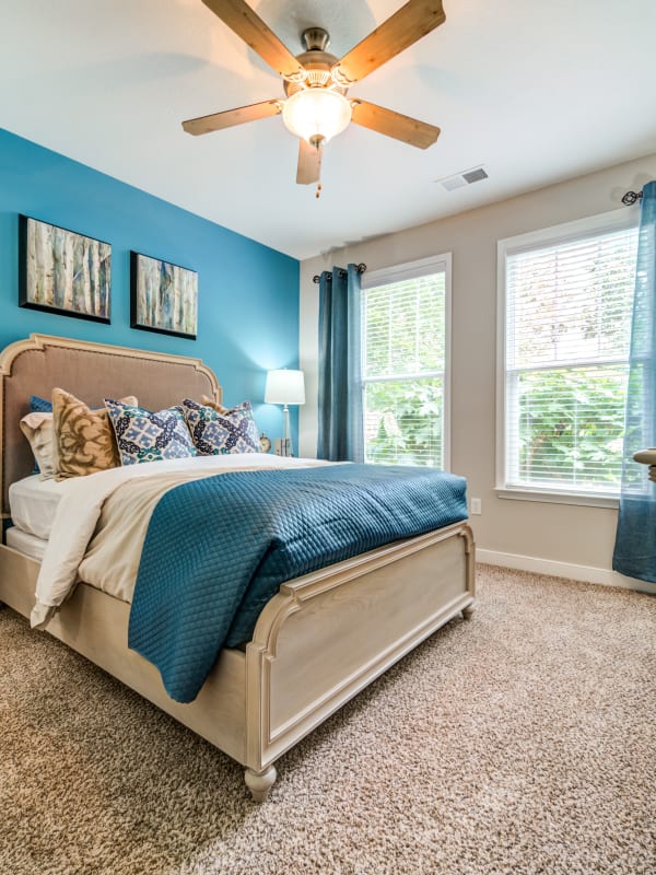 Cozy bedroom with ceiling fan and carpeted floors in a model home at Reserve at Biltmore Park in Arden, North Carolina