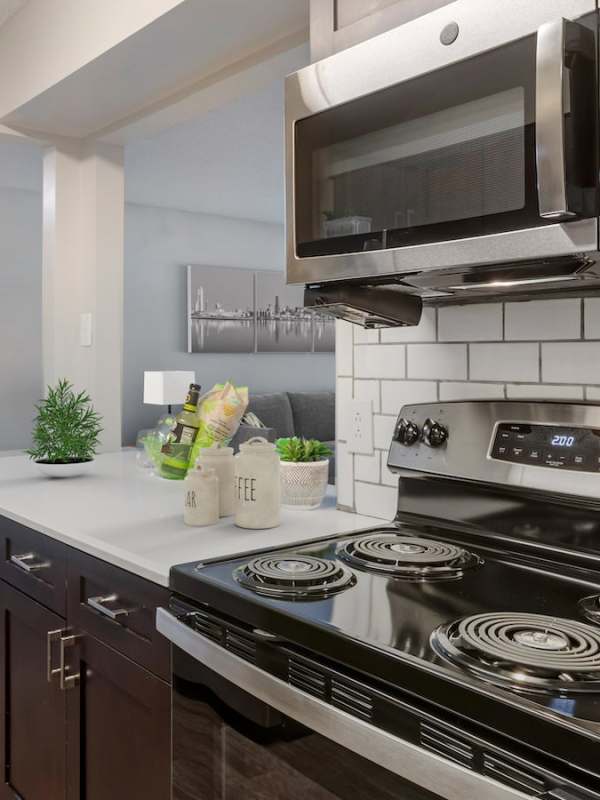 Tile backsplash and stainless-steel appliances in a kitchen at The Greens At Peachtree City in Peachtree City, Georgia