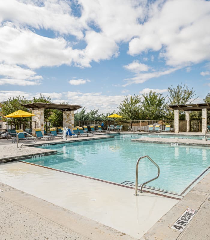 Sparkling swimming pool with sundeck at The Residences at Panther Hollow in Marble Falls, Texas