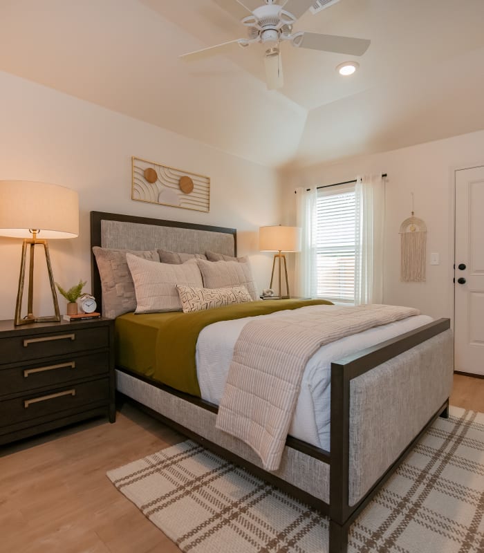 A model bedroom with gold accents at Chisholm Pointe in Oklahoma City, Oklahoma