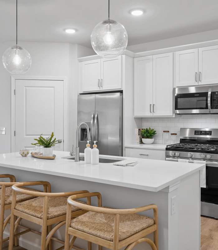 Canterbury Model Kitchen with white cabinets and stainless appliances and quartz countertops